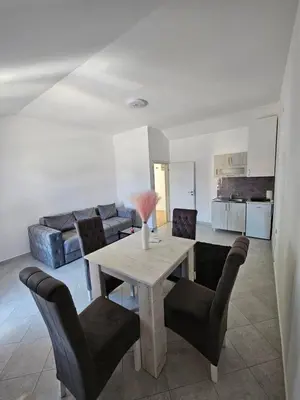a living room with a wooden table and chairs at Stan na dan Crystal in Paraćin