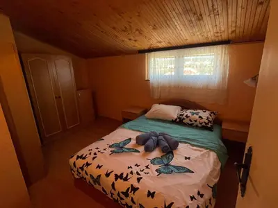 a small bedroom with a bed with leaves on it at Apartman Janković in Paraćin