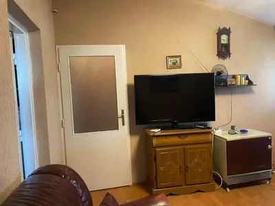 a living room with a flat screen tv on a wooden cabinet at Apartman Janković in Paraćin
