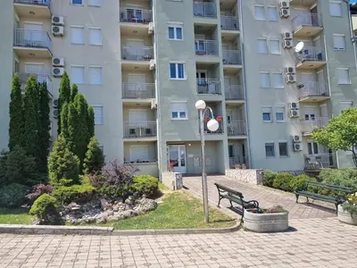 a park bench in front of a building at Apartman Ilić 1 in Vrnjačka Banja