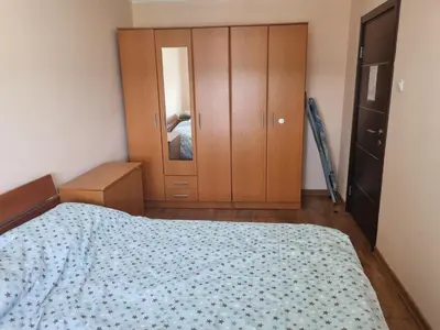a bedroom with a bed and a wooden cabinet at Apartman Ilić 1 in Vrnjačka Banja