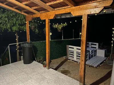 a wooden pergola with a bench on a patio at Apartmani Stankovic in Crni Vrh