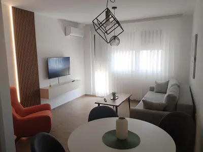 a living room with a couch and a table at Merak stay 018 in Niš