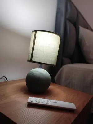 a lamp on a table next to a remote control at Merak stay 018 in Niš