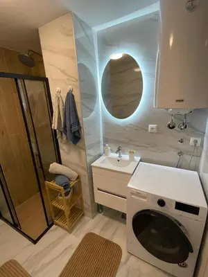 a bathroom with a sink and a washing machine at Merak stay 018 in Niš