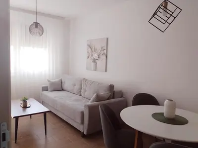 a living room with a couch and a table at Merak stay 018 in Niš