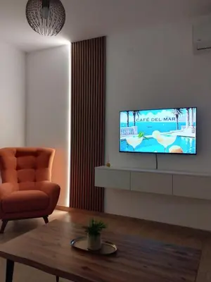 a living room with a flat screen tv on a wall at Merak stay 018 in Niš