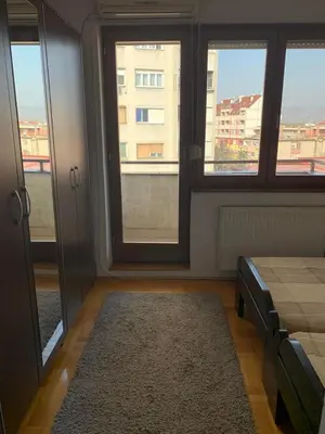 a bedroom with windows and a bed with a rug at Katarina in Niš