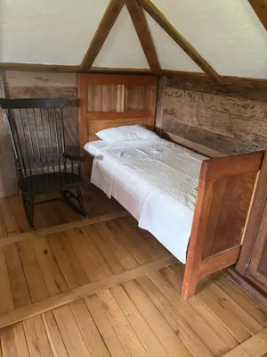 a small bedroom with a bed and a chair at Brvnara 