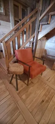 an orange chair in a room with wooden floors at Brvnara 