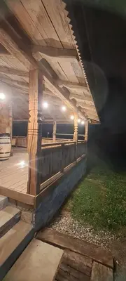 a patio with a wooden deck at night at Brvnara 