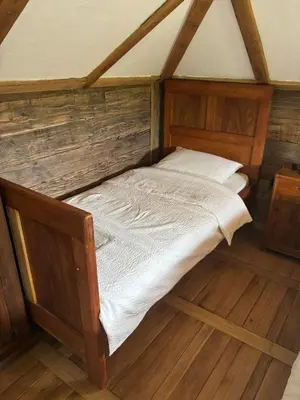 a bed in a room with a wooden floor at Brvnara 