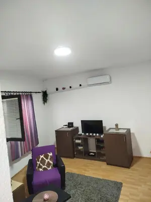 a living room with a purple chair and a tv at Milić in Jagodina