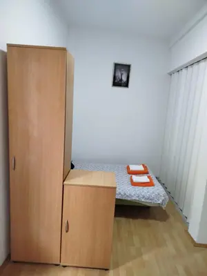 a bedroom with a bed and a wooden cabinet at Milić in Jagodina