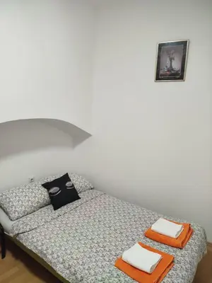 a small bedroom with a bed with towels on it at Milić in Jagodina