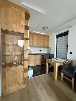 a kitchen with wooden cabinets and a table in a room at Four seasons in Vrnjačka Banja