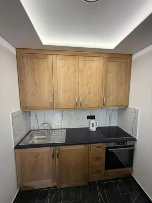a kitchen with wooden cabinets and a sink at Four seasons in Vrnjačka Banja