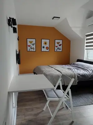a bedroom with a bed and a table and a desk at Top 4 Sobe, Rooms - Near the airport in Niš