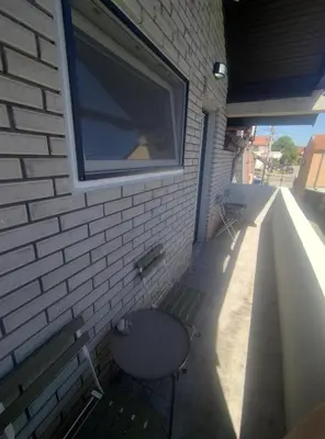 a building with a bench and a window on it at Top 4 Sobe, Rooms - Near the airport in Niš