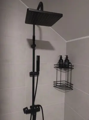 a bathroom with a shower with two shelves on the wall at Top 4 Sobe, Rooms - Near the airport in Niš