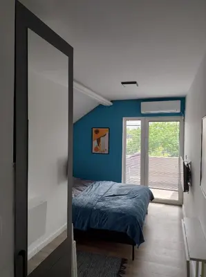 a bedroom with a bed with a blue wall at Top 4 Sobe, Rooms - Near the airport in Niš