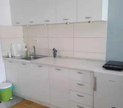 a kitchen with white cabinets and a sink at Leon Apartman in Vrnjačka Banja