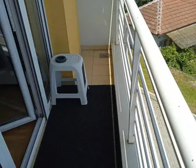 a stairway with a white stool on a balcony at Leon Apartman in Vrnjačka Banja