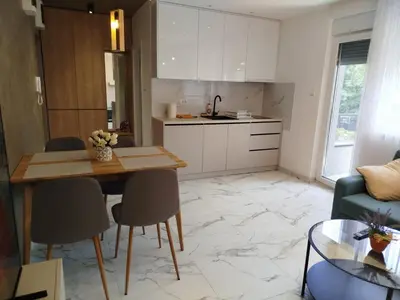 a kitchen and living room with a table and chairs at Vista MDD in Soko Banja