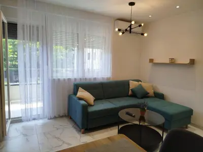 a living room with a green couch and a table at Vista MDD in Soko Banja