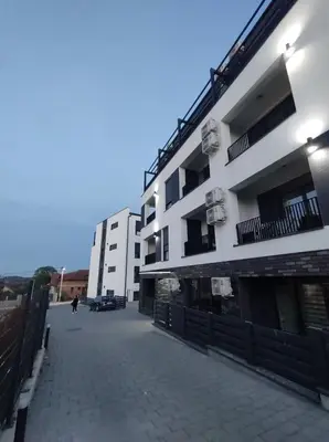 a large white building with balconies on a street at Apartman Jeca in Vrnjačka Banja