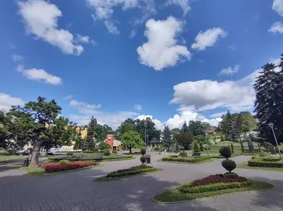 a park with a blue sky and clouds at Apartman Jeca in Vrnjačka Banja