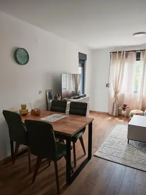 a living room with a wooden table and chairs at Grabak B3 in Vrnjačka Banja
