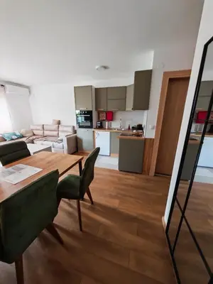a living room with a table and chairs and a kitchen at Grabak B3 in Vrnjačka Banja