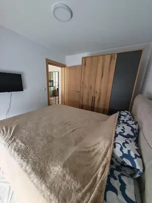 a bedroom with a large bed with a wooden headboard at Grabak B3 in Vrnjačka Banja
