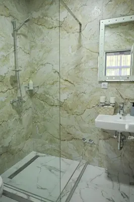 a bathroom with a sink and a glass shower at Apartmani kod kumašina in Kuršumlija