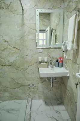 a bathroom with a sink and a mirror at Apartmani kod kumašina in Kuršumlija