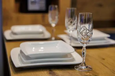 a table with white plates and wine glasses on it at Harmonia Lux Aqua park in Jagodina