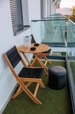 a wooden table and chair sitting on a balcony at Harmonia Lux Aqua park in Jagodina