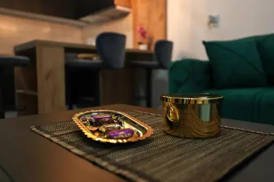 a table with a gold container on top of a table at Zeus Apartman in Jagodina