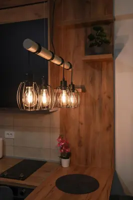 a kitchen with a table with lights on it at Zeus Apartman in Jagodina