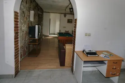 a hallway leading to a kitchen with a table and a desk at Apartman Borići - nostalgija in Soko Banja