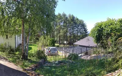 a car parked in a yard next to a house at Apartman Borići - nostalgija in Soko Banja