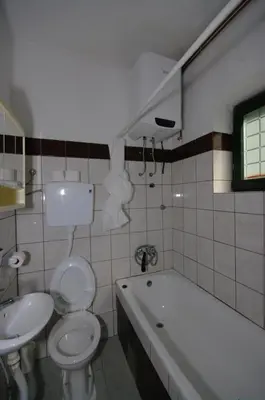 a bathroom with a toilet and a tub and a sink at Apartman Borići - nostalgija in Soko Banja