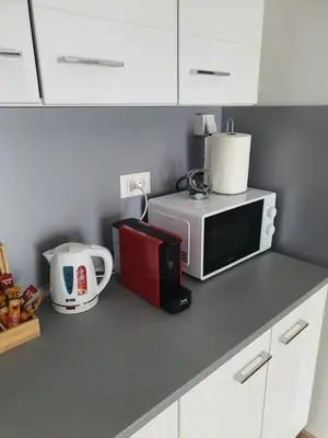 a kitchen counter with a microwave and a coffee maker at Family Lux Raj in Vrnjačka Banja