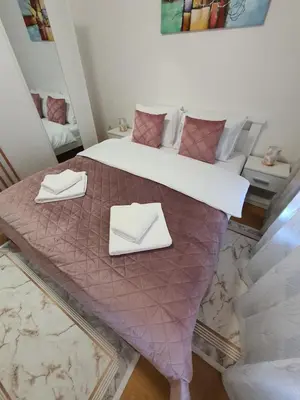 a bedroom with a bed with two napkins on it at Family Lux Raj in Vrnjačka Banja