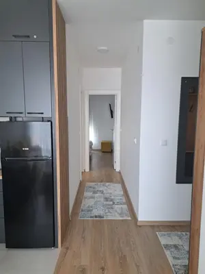 a kitchen with a black refrigerator and a hallway at Rajsko sunce in Vrnjačka Banja