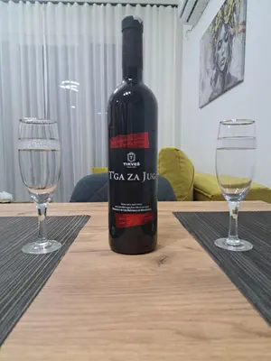 a bottle of wine sitting on a table with two glasses at Rajsko sunce in Vrnjačka Banja