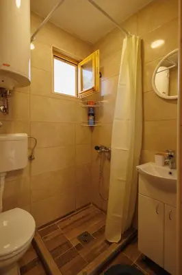 a bathroom with a shower and a toilet and a sink at Brvnara Dadi