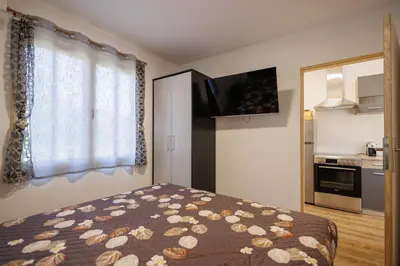 a small bedroom with a bed and a kitchen at Brvnara Dadi