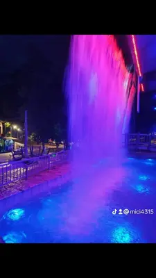 a fountain with pink and purple lights in the water at Apartman M&M in Jagodina